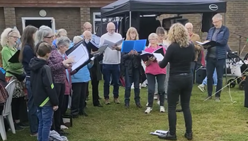 The choir singing outside the village hall